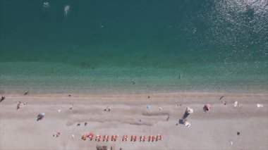 Bu video Türkiye 'de Akdeniz kıyısındaki bir plajın 8K çözünürlükteki havadan görüntüsünü gösteriyor