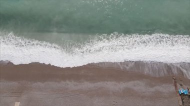 Bu video Türkiye 'de Akdeniz kıyısındaki bir plajın 8K çözünürlükteki havadan görüntüsünü gösteriyor