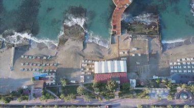 Bu video Türkiye 'de Akdeniz kıyısındaki bir plajın 8K çözünürlükteki havadan görüntüsünü gösteriyor