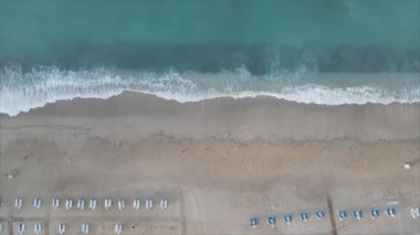 Bu video Türkiye 'de Akdeniz kıyısındaki bir plajın 8K çözünürlükteki havadan görüntüsünü gösteriyor