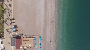 Bu video Türkiye 'de Akdeniz kıyısındaki bir plajın 8K çözünürlükteki havadan görüntüsünü gösteriyor