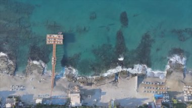 Bu video Türkiye 'de Akdeniz kıyısındaki bir plajın 8K çözünürlükteki havadan görüntüsünü gösteriyor