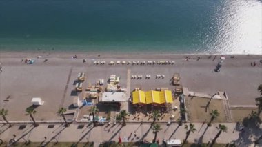 Bu video Türkiye 'de Akdeniz kıyısındaki bir plajın 8K çözünürlükteki havadan görüntüsünü gösteriyor