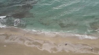 Bu video Türkiye 'de Akdeniz kıyısındaki bir plajın 8K çözünürlükteki havadan görüntüsünü gösteriyor