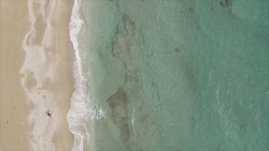 Bu video Türkiye 'de Akdeniz kıyısındaki bir plajın 8K çözünürlükteki havadan görüntüsünü gösteriyor