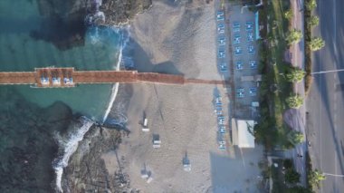 Bu video Türkiye 'de Akdeniz kıyısındaki bir plajın 8K çözünürlükteki havadan görüntüsünü gösteriyor