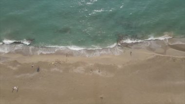 Bu video Türkiye 'de Akdeniz kıyısındaki bir plajın 8K çözünürlükteki havadan görüntüsünü gösteriyor