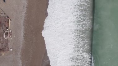 Bu video Türkiye 'de Akdeniz kıyısındaki bir plajın 8K çözünürlükteki havadan görüntüsünü gösteriyor