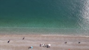Bu video Türkiye 'de Akdeniz kıyısındaki bir plajın 8K çözünürlükteki havadan görüntüsünü gösteriyor