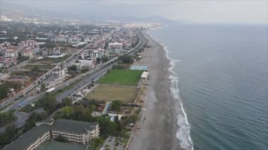 Bu video Türkiye 'de Akdeniz kıyısındaki bir plajın 8K çözünürlükteki havadan görüntüsünü gösteriyor