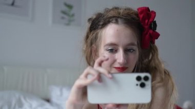 This stock video shows a young girl taking a selfie on her phone, slow motion