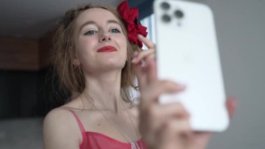 This stock video shows a young girl taking a selfie on her phone, slow motion