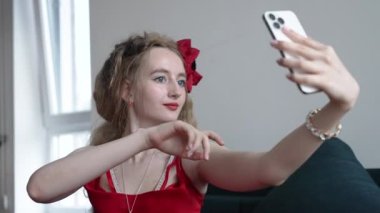 This stock video shows a young girl taking a selfie on her phone, slow motion