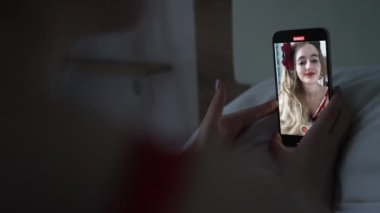 This stock video shows a young girl taking a selfie on her phone, slow motion