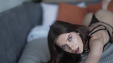 Bu yavaş çekim videosu seksi iç çamaşırlı güzel bir kadını gösteriyor.