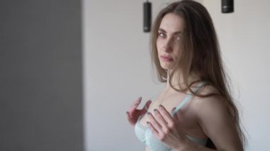 Bu yavaş çekim videosu seksi iç çamaşırlı güzel bir kadını gösteriyor.