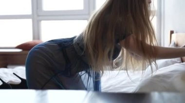 Bu yavaş çekim videosu seksi iç çamaşırlı güzel bir kadını gösteriyor.