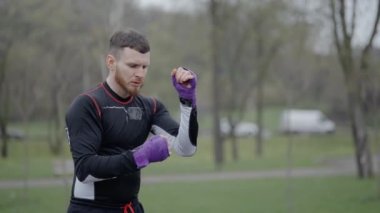 Erkek boksör şehirde spor eğitimi alıyor, ağır çekimde.