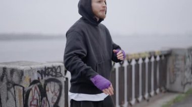 Erkek boksör şehirde spor eğitimi alıyor, ağır çekimde.