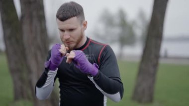 Erkek boksör şehirde spor eğitimi alıyor, ağır çekimde.