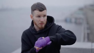 Erkek boksör şehirde spor eğitimi alıyor, ağır çekimde.