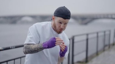 Erkek boksör şehirde spor eğitimi alıyor, ağır çekimde.