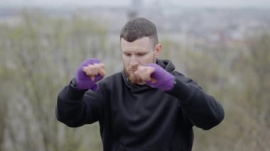 Erkek boksör şehirde spor eğitimi alıyor, ağır çekimde.