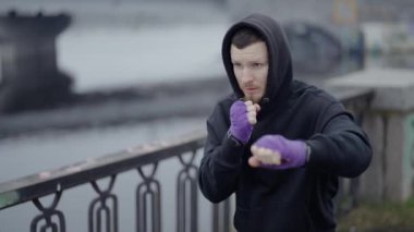 Erkek boksör şehirde spor eğitimi alıyor, ağır çekimde.