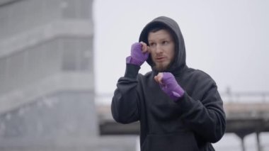 Erkek boksör şehirde spor eğitimi alıyor, ağır çekimde.