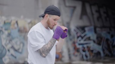 Erkek boksör şehirde spor eğitimi alıyor, ağır çekimde.