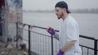 Erkek boksör şehirde spor eğitimi alıyor, ağır çekimde.