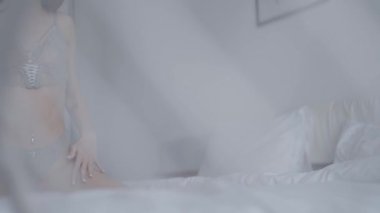 Bu yavaş çekim videosu seksi iç çamaşırlı güzel bir kadını gösteriyor.