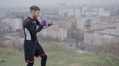 Erkek boksör şehirde spor eğitimi alıyor.