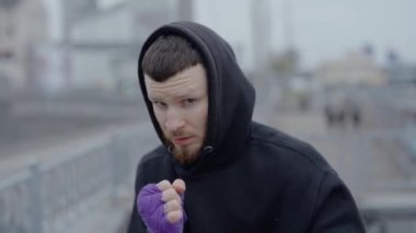 Erkek boksör şehirde spor eğitimi alıyor.