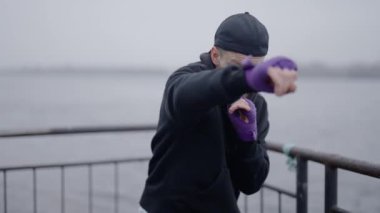 Erkek boksör şehirde spor eğitimi alıyor.