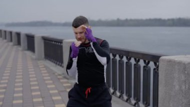 Erkek boksör şehirde spor eğitimi alıyor.