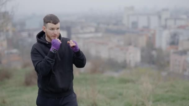 男性ボクサーは市内の屋外スポーツトレーニングに従事しています — ストック動画