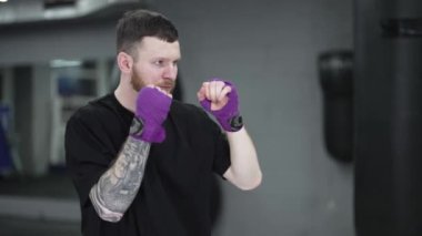 Spor salonunda ağır çekimde erkek boksör.