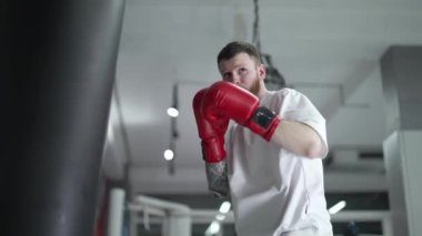 Spor salonunda ağır çekimde erkek boksör.