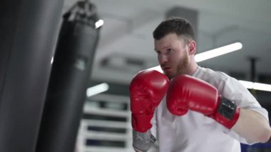 Spor salonunda ağır çekimde erkek boksör.