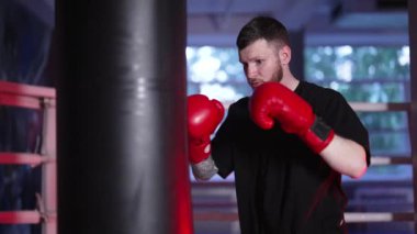 Spor salonunda ağır çekimde erkek boksör.