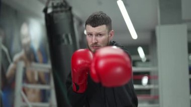 Spor salonunda ağır çekimde erkek boksör.