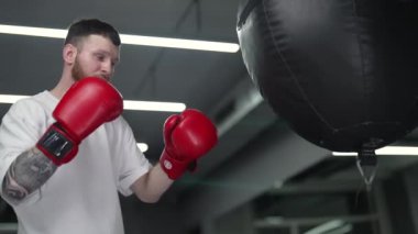 Spor salonunda ağır çekimde erkek boksör.