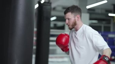 Spor salonunda ağır çekimde erkek boksör.