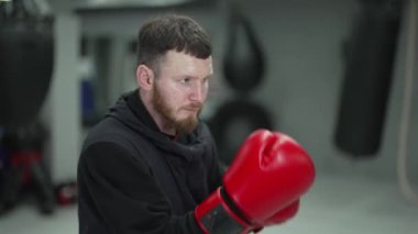 Spor salonunda ağır çekimde erkek boksör.