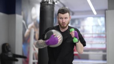 Spor salonunda ağır çekimde erkek boksör.