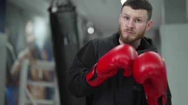 Spor salonunda ağır çekimde erkek boksör.
