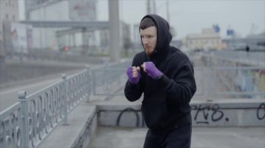 Erkek boksör şehir dışında spor antrenmanında, yavaş çekim ise 8K 'da.