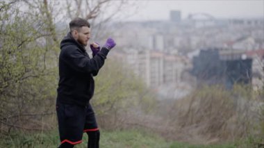 Erkek boksör şehir dışında spor antrenmanında, yavaş çekim ise 8K 'da.