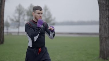 Erkek boksör şehir dışında spor antrenmanında, yavaş çekim ise 8K 'da.